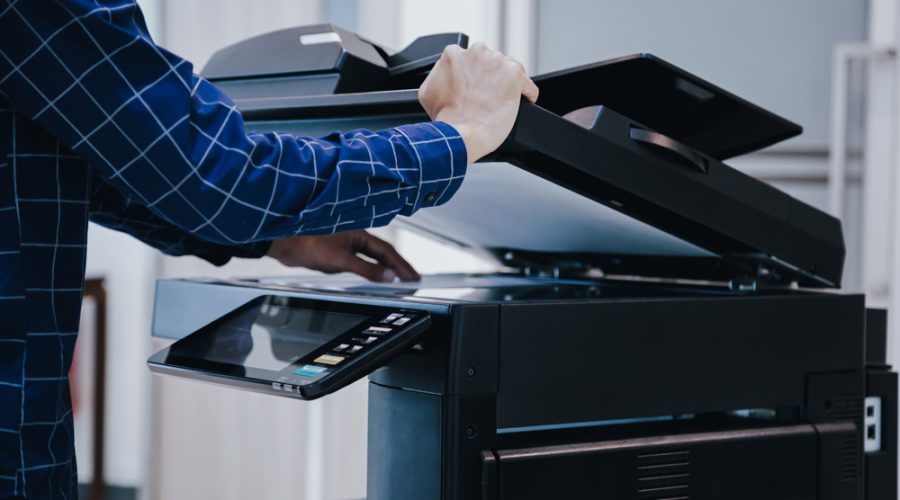 Business professional scanning documents on a multifunction office printer in a Minneapolis workplace