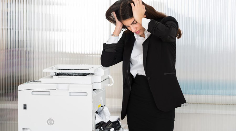 Frustrated business professional with jammed printer — McNallan Technology provides quick printer repair solutions in Minneapolis, MN